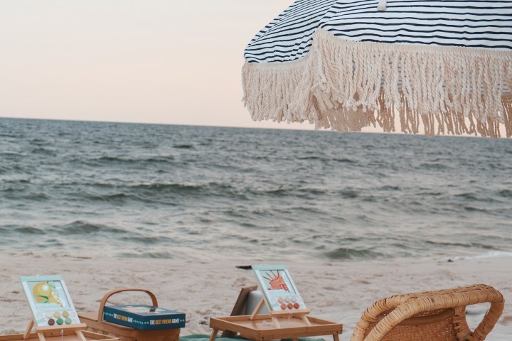Beach setup with chairs, table, and umbrella near the sea.